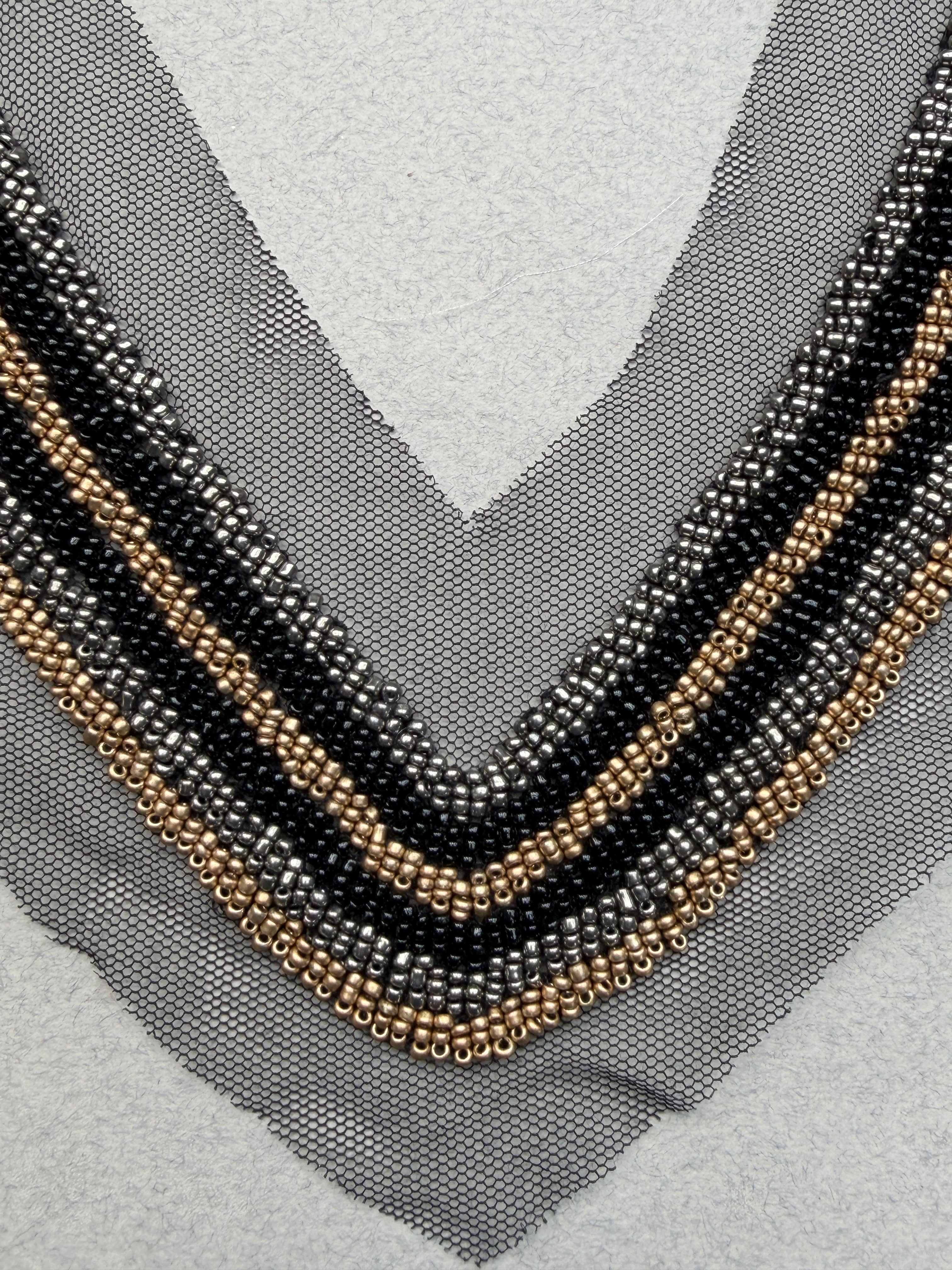 Close up black gold beads sewn on net neckline trim  SP Haberdashery Auckland NZ