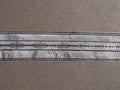 Silver satin ribbon with embroidery and black stitching 32mm wide