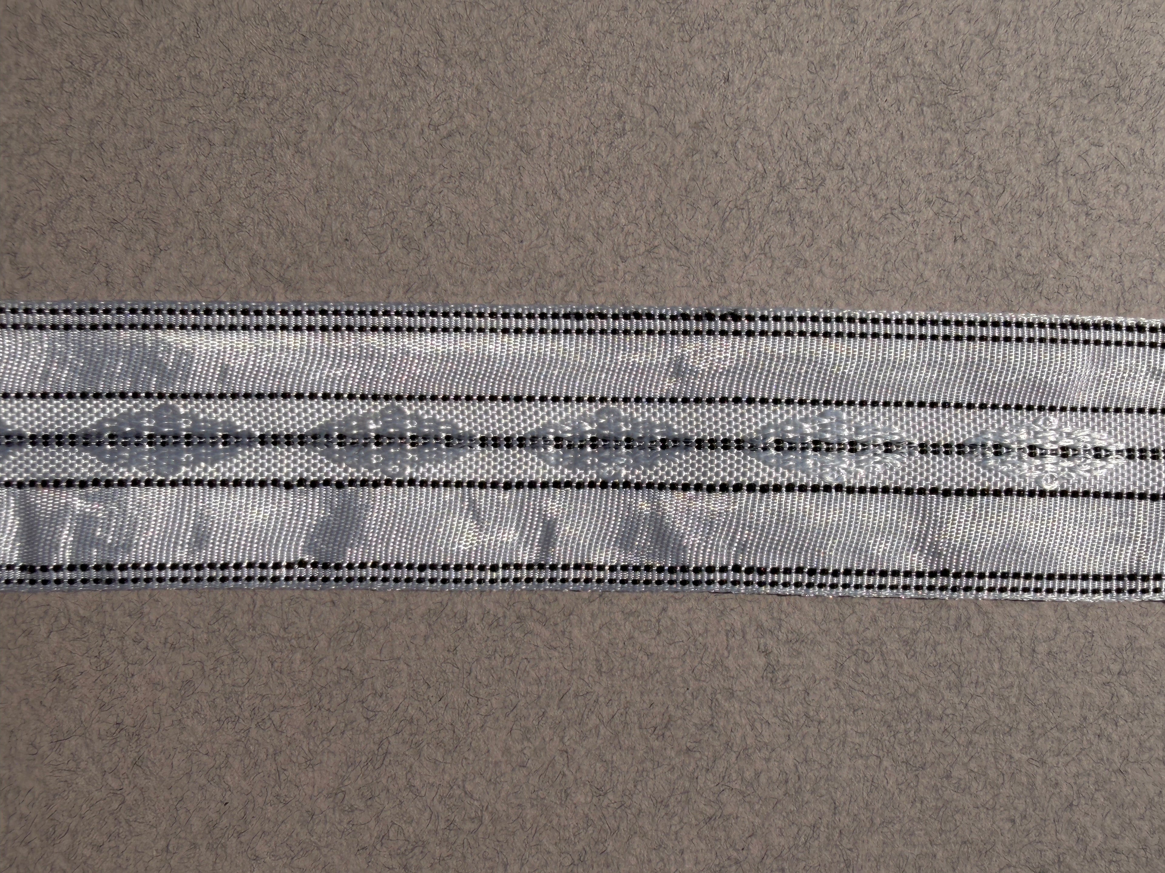 Silver satin ribbon with embroidery and black stitching 32mm wide