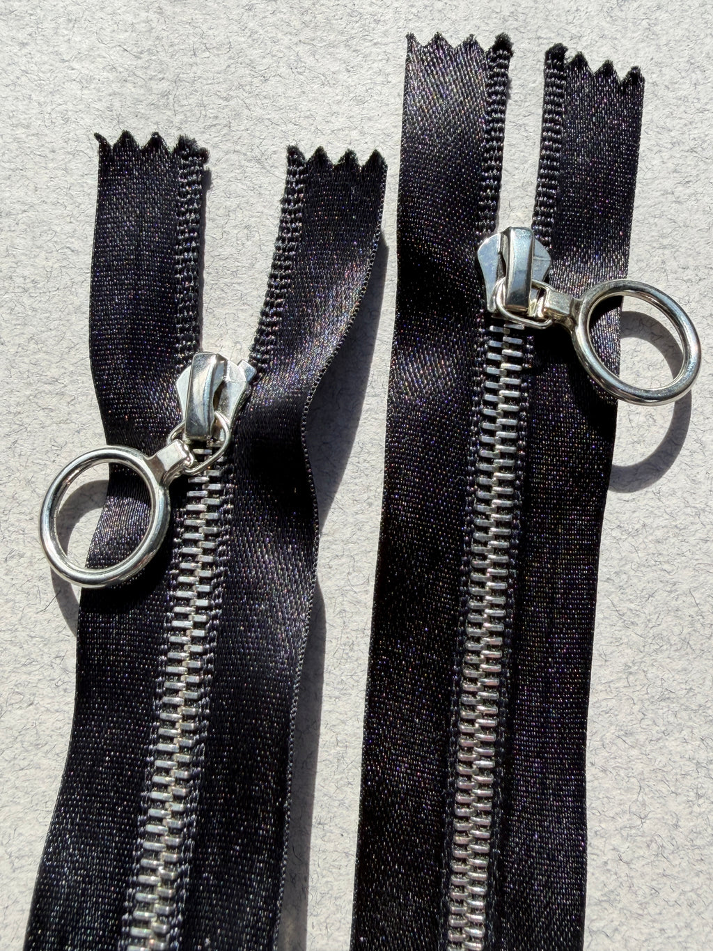 Close up Riri open end two ways metal black satin zip
