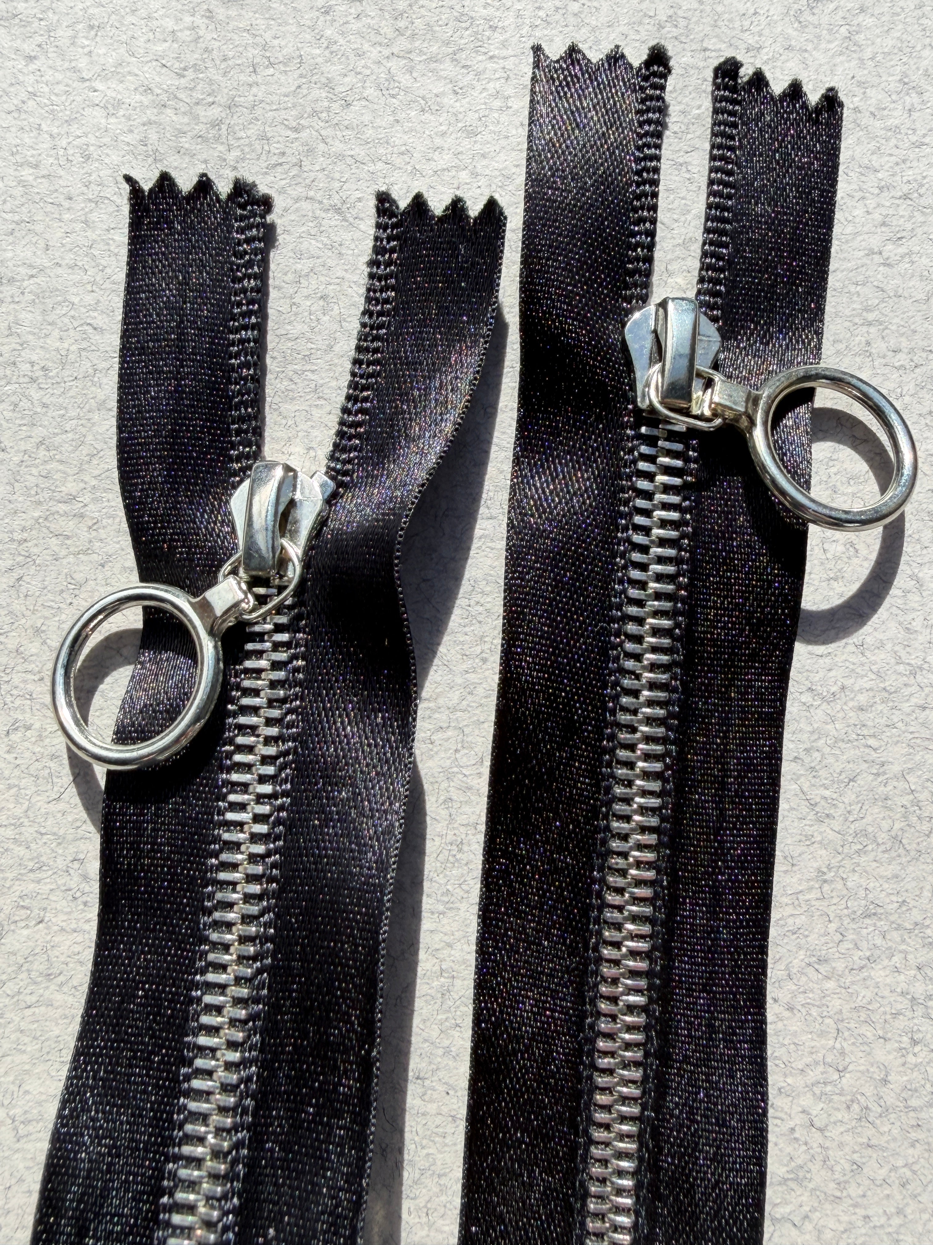 Close up Riri open end two ways metal black satin zip
